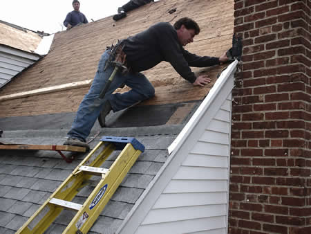 Crew removing old shingles from a Metairie, LA home during roof replacement
